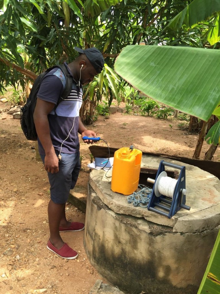 Obed taking a sample and measuring chemical parameters in the field